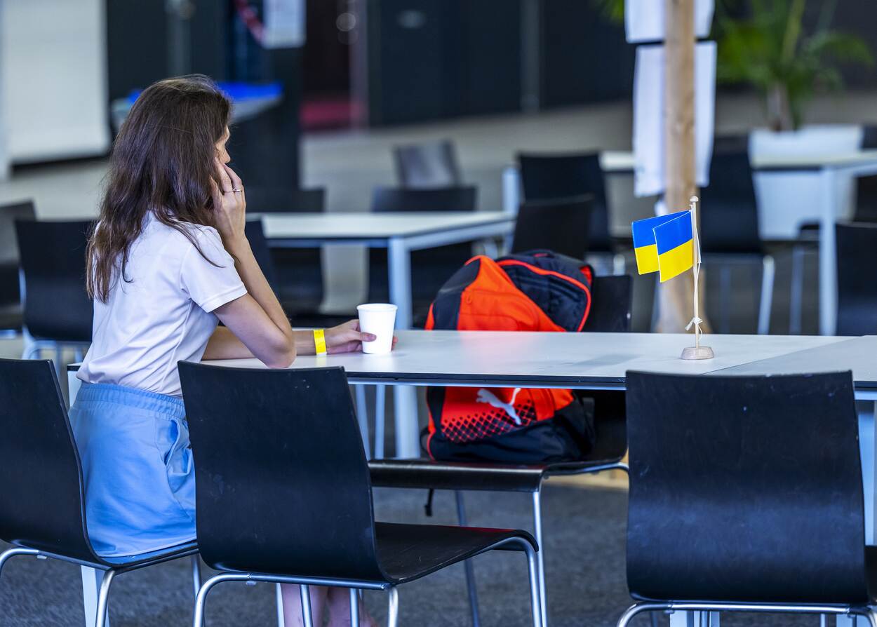 Oekraïense vrouw zit aan tafel met vlaggetje thuisland