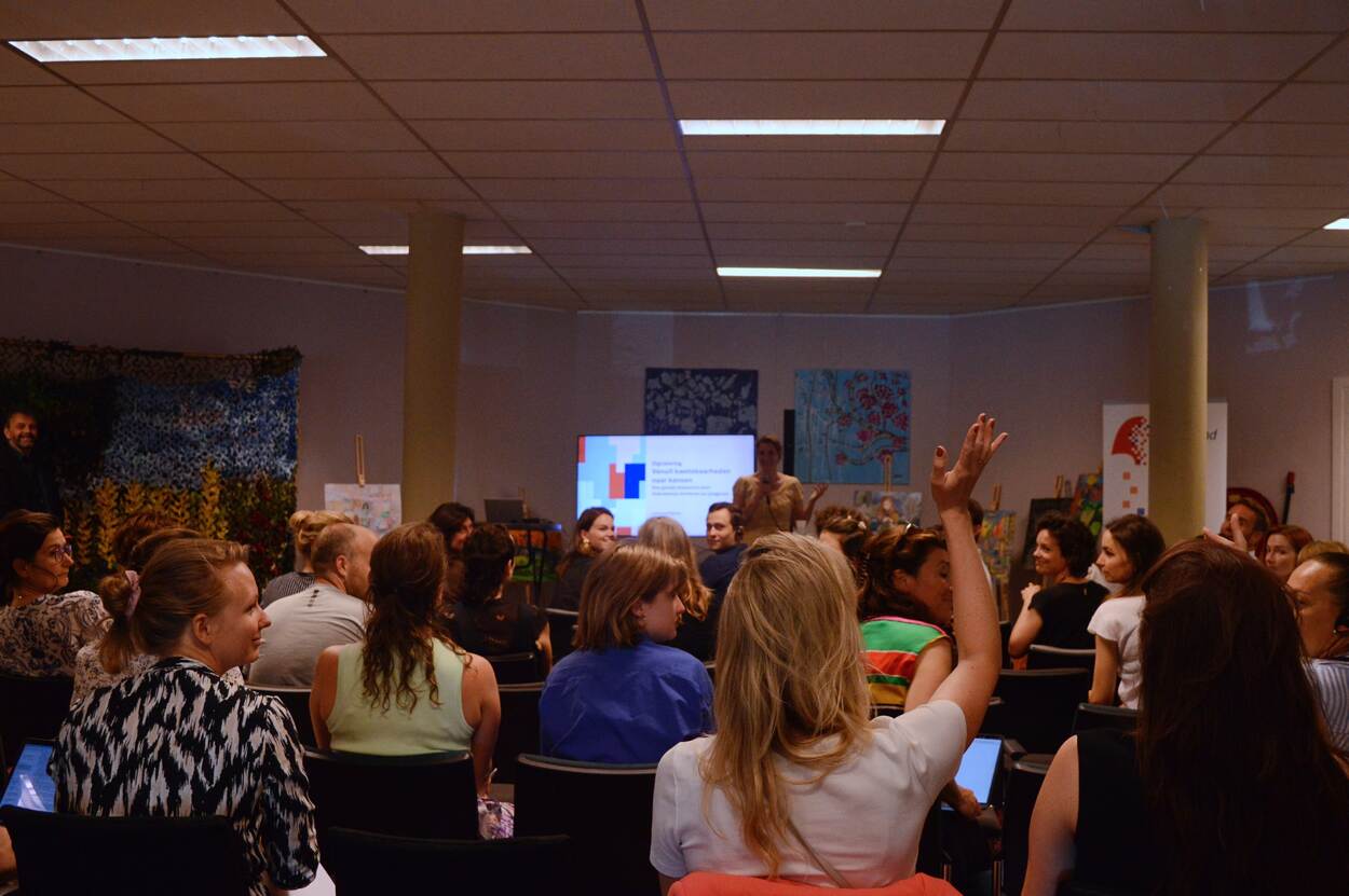 Mensen in de zaal tijdens presentatie verkenning 'Vanuit kwetsbaarheden naar kansen'