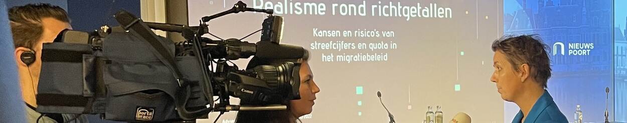 Voorzitter M. Kremer wordt geïnterviewd door een journalist bij Nieuwspoort