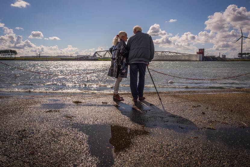 Twee ouderen staan aan de rivier