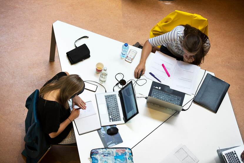 Drie studenten aan een tafel